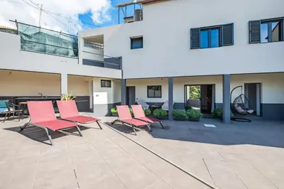 a group of chairs sitting on a patio in front of a building at Tornos in Funchal