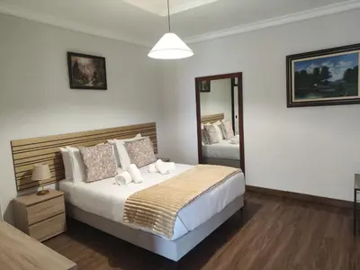 a bedroom with a large bed and a mirror at Quinta do Araújo - GuestHouses in Câmara de Lobos