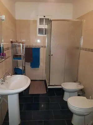 a bathroom with two sinks and a shower and a toilet at Madeira house garden Villa in Estreito de Câmara de Lobos