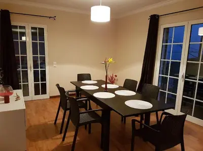 a dining room with a black table and chairs at Madeira house garden Villa in Estreito de Câmara de Lobos