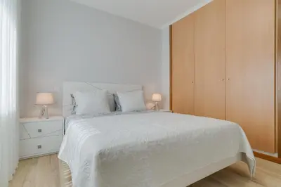 a white bedroom with a white bed and a cabinet at Villa Quinta Grande by Holiday rental Madeira in Quinta Grande