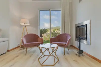 a living room with two chairs and a table and a tv at Villa Quinta Grande by Holiday rental Madeira in Quinta Grande