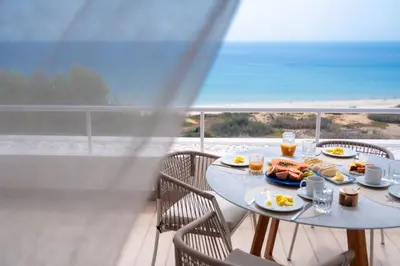 a table with food and a view of the ocean at Porto Santo Precious Oceanview in Campo de Baixo