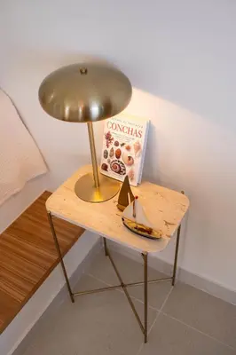 a table with a lamp and a book on it at Porto Santo Precious Oceanview in Campo de Baixo