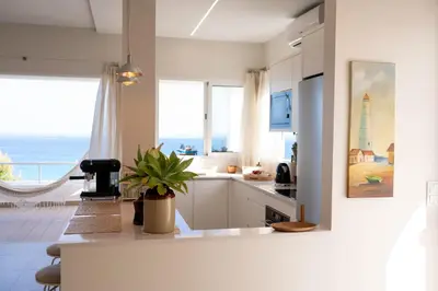 a white kitchen with a view of the ocean at Porto Santo Precious Oceanview in Campo de Baixo