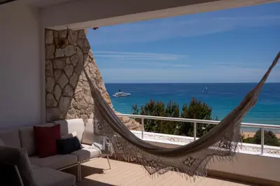 a hammock in a living room with a view of the ocean at Porto Santo Precious Oceanview in Campo de Baixo