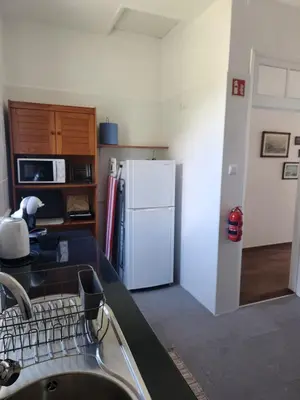 a kitchen with a sink and a white refrigerator at Oscar House Free Parking in São Vicente