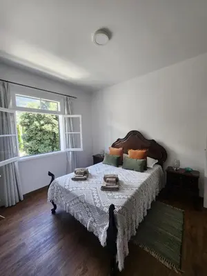 a bedroom with a large bed with a table on it at Oscar House Free Parking in São Vicente