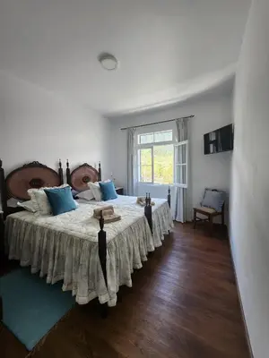 a bedroom with a large bed with blue pillows at Oscar House Free Parking in São Vicente