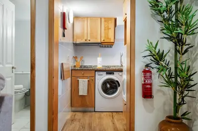 a small kitchen with a washer and dryer at Harmony Retreat by Homie in Ponta do Sol