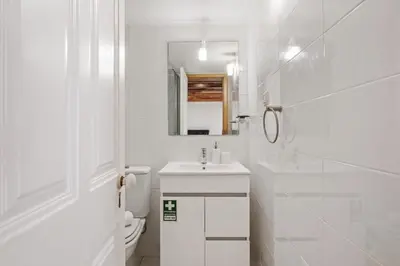 a white bathroom with a sink and a mirror at Harmony Retreat by Homie in Ponta do Sol