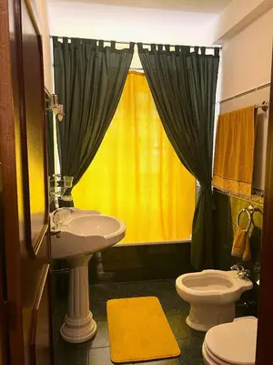 a bathroom with a sink and a yellow shower curtain at Vale dos Passarinhos in São Vicente