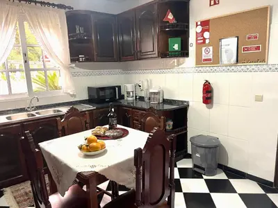 a kitchen with a table with a bowl of fruit on it at Vale dos Passarinhos in São Vicente