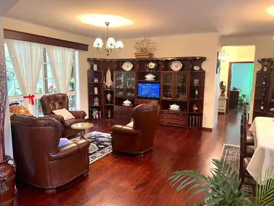 a living room with leather chairs and a television at Vale dos Passarinhos in São Vicente
