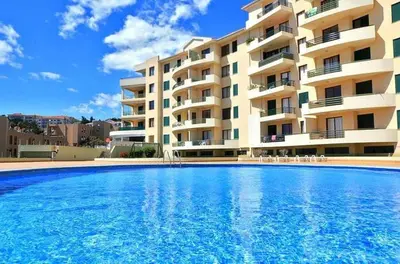 a large swimming pool in front of a building at Estúdio Costinha - Madeira in Garajau