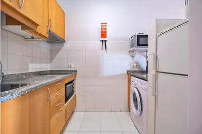 a kitchen with a refrigerator and a washing machine at Estúdio Costinha - Madeira in Garajau