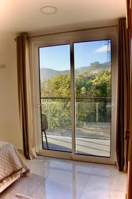 a bedroom with a sliding glass door with a view of a mountain at Golden Moon, Ponta do Sol in Ponta do Sol
