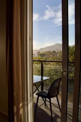 a table and a chair on a balcony with a view at Golden Moon, Ponta do Sol in Ponta do Sol