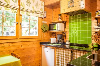 a kitchen with wooden walls and green tiles at Casas Maravilha by Homie in Calheta