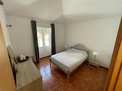 a white bed in a room with two lamps at Cantinho DC in Funchal