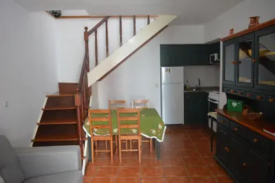 a kitchen with a dining room table and a staircase at Cantinho DC in Funchal