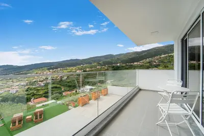 a view from the balcony of a house with a table and chairs at Brand new apartment - Balcony with sea view in Arco da Calheta