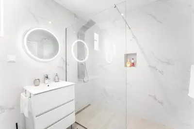 a white bathroom with a shower and a sink at Brand new apartment - Balcony with sea view in Arco da Calheta