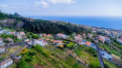 an aerial view of a small town on a hill at Brand new apartment - Balcony with sea view in Arco da Calheta