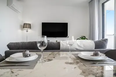 a living room with a couch and a table with wine glasses at Brand new apartment - Balcony with sea view in Arco da Calheta