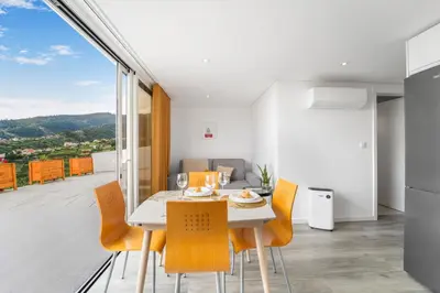 a kitchen and dining room with a table and chairs at Brand new private modern apartment with Patio and Sea View in Calheta