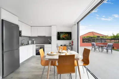 a kitchen and dining room with a table and chairs at Brand new private modern apartment with Patio and Sea View in Calheta