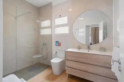 a bathroom with a toilet and a sink and a mirror at Casa da Palmeira by An Island Apart in Porto Santo