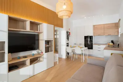 a living room and kitchen with a couch and a television at Casa da Palmeira by An Island Apart in Porto Santo