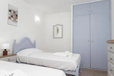 a white bedroom with two beds and a closet at Apartamentos Jorge Águas - 2Bedroom in the town of Burgau - Sea view in Burgau