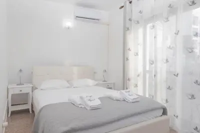 a white bedroom with a bed with towels on it at Apartamentos Jorge Águas - 2Bedroom in the town of Burgau - Sea view in Burgau