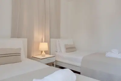 two beds in a room with a nightstand between them at Upgrade Paradise Apartments Funchal City Centre in Funchal