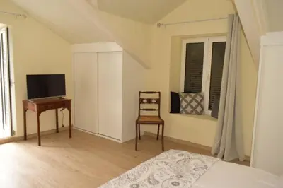 a bedroom with a bed and a desk and a television at Sonho Paixão in São Vicente