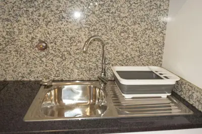 a kitchen counter with a sink and a toaster at Sonho Paixão in São Vicente