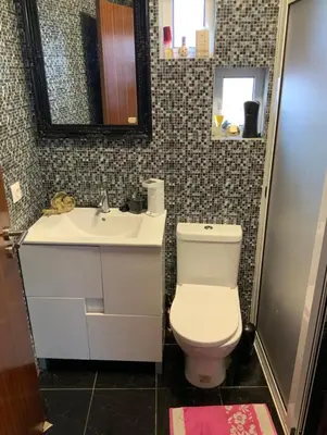 a bathroom with a white toilet and a sink at Quinta J.V. in Camacha