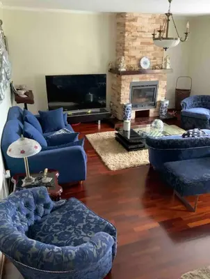 a living room with blue couches and a fireplace at Quinta J.V. in Camacha