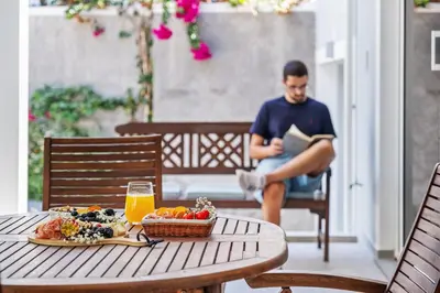 a man reading a book while sitting at a table at Coastal Charm by Homie in Ponta do Sol