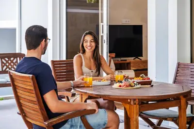 a man and woman sitting at a table eating food at Coastal Charm by Homie in Ponta do Sol