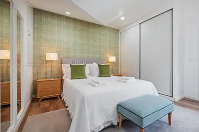 a bedroom with a large white bed and a blue stool at Coastal Charm by Homie in Ponta do Sol