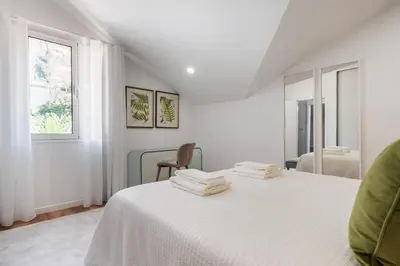 a white bedroom with a bed and a window at Coastal Charm by Homie in Ponta do Sol