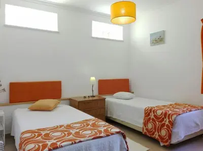 a bedroom with two beds and a yellow light at Casa do Guarda - Arrifana beach 5min walk in Praia da Arrifana