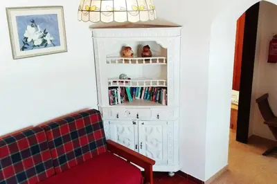 a white cabinet with a red couch in a room at Casa do Guarda - Arrifana beach 5min walk in Praia da Arrifana