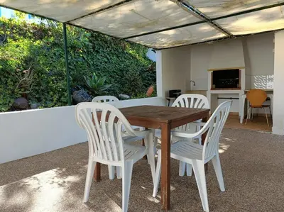 a wooden table and four white chairs on a patio at Casa do Guarda - Arrifana beach 5min walk in Praia da Arrifana