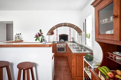 a kitchen with wooden cabinets and a sink and a counter at Casa Azul da Corisca in São Lourenço