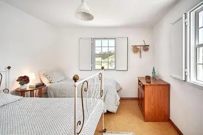 a bedroom with two beds and a window at Casa Azul da Corisca in São Lourenço