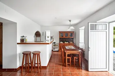 a kitchen with a table and stools in it at Casa Azul da Corisca in São Lourenço